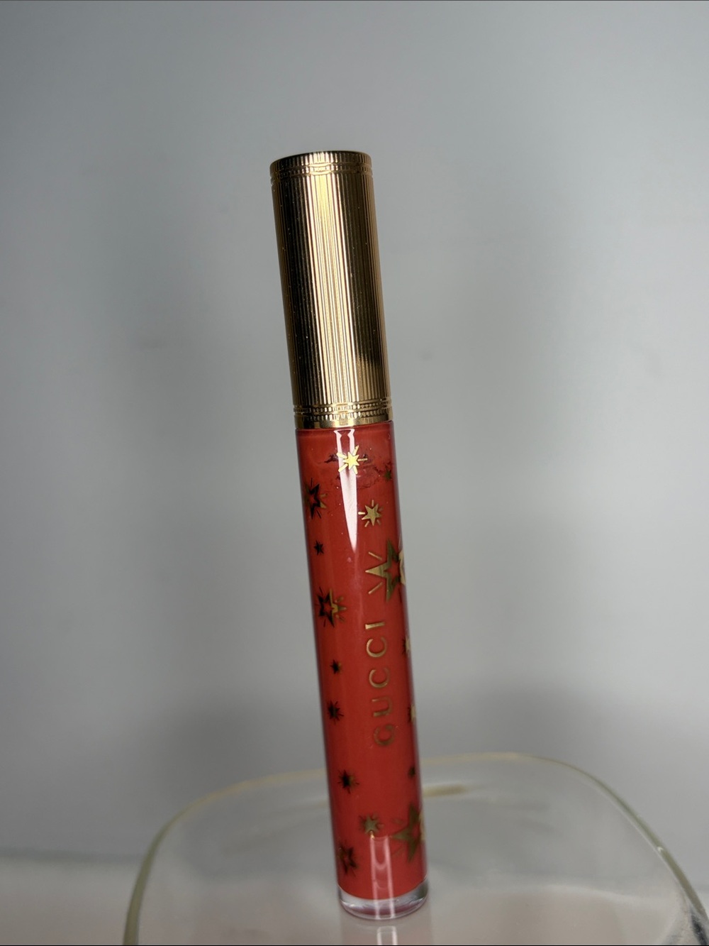 Gucci Coral-Red Lip Gloss with Gold Cap and Star Motif in Suzanne
